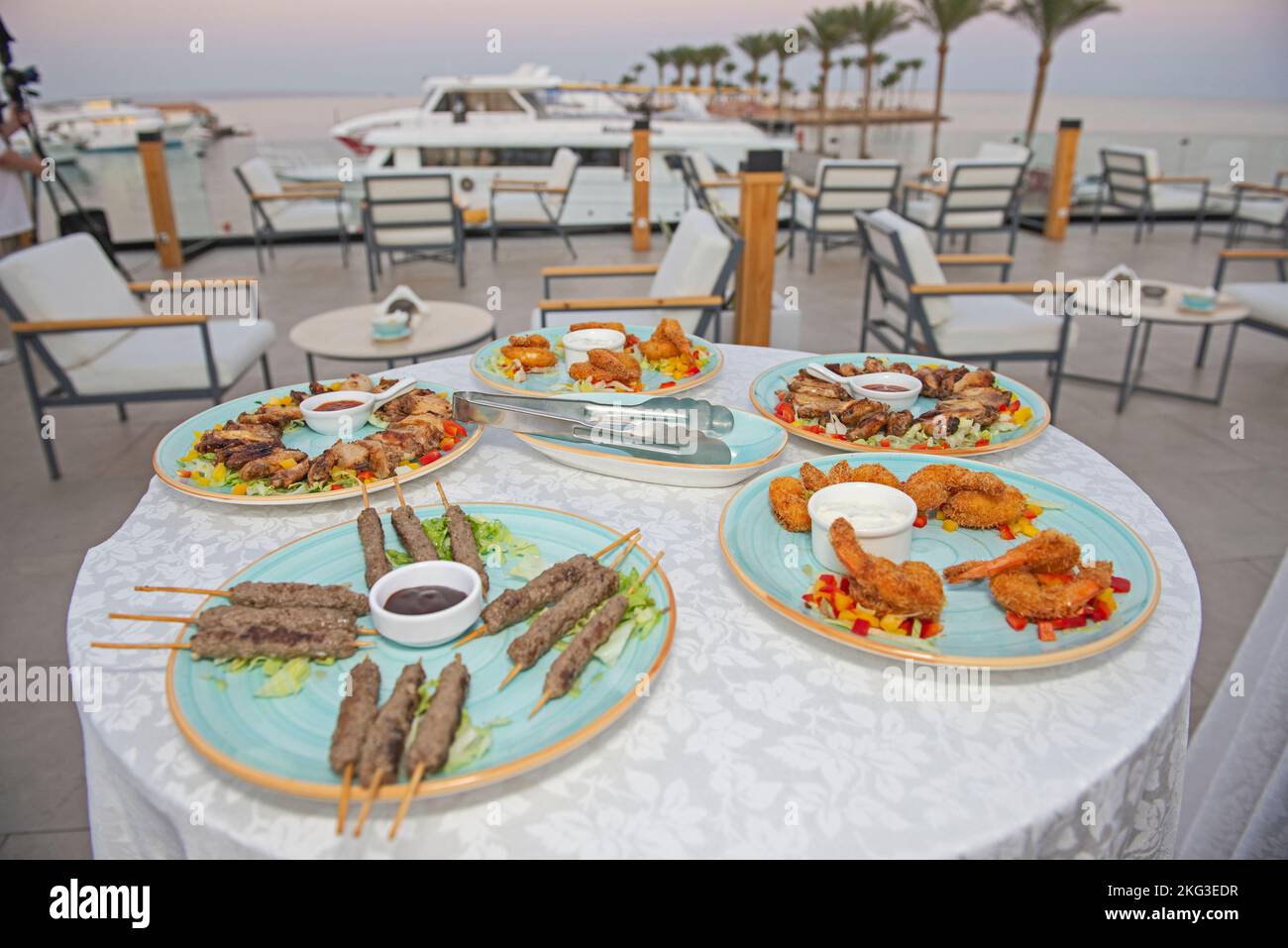 Selezione di piatti a base di carne e finger food su un tavolo presso il lussuoso ristorante all'aperto con area buffet con vista sul porto turistico Foto Stock