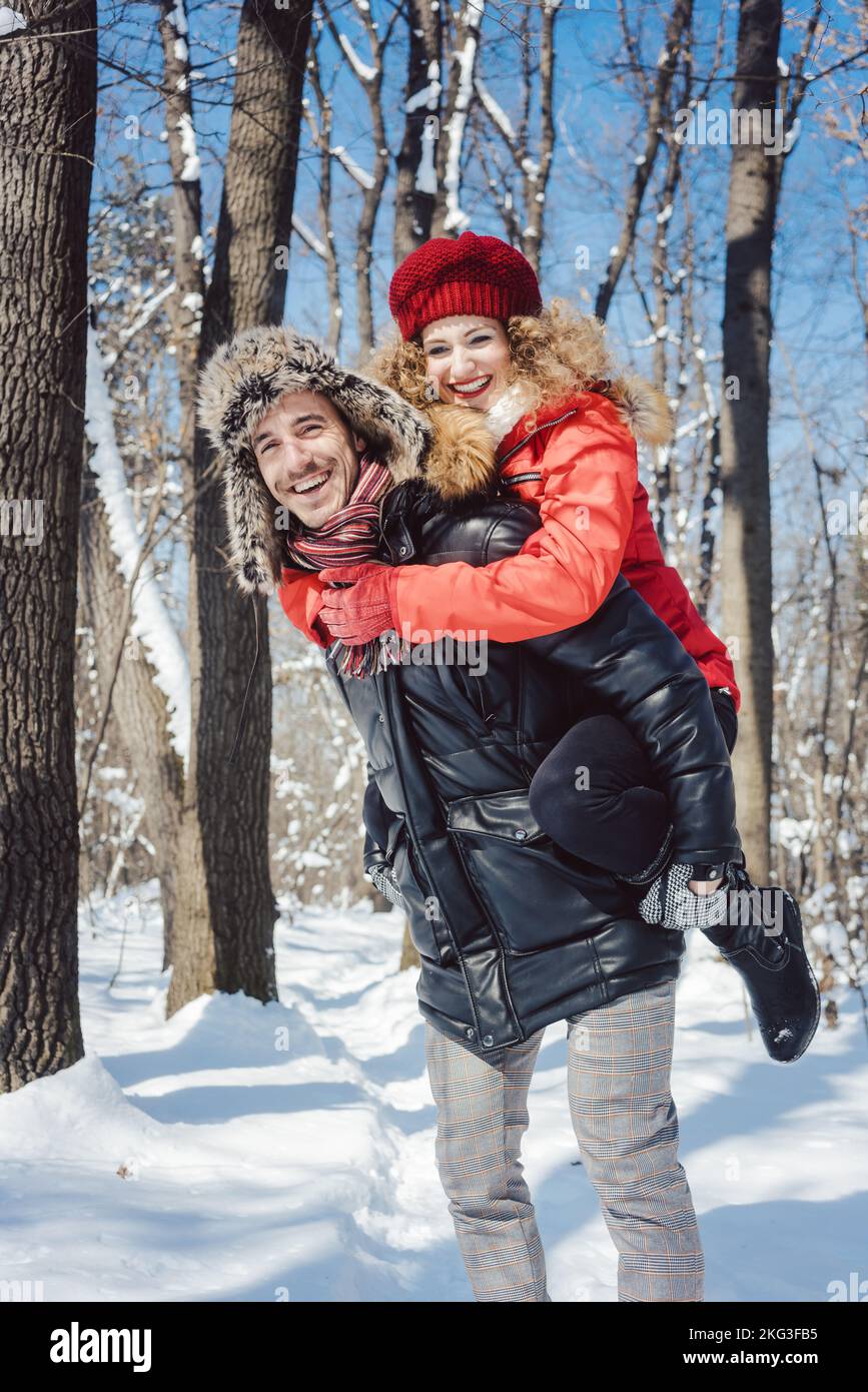 Uomo che porta la sua donna trasportato su una giornata invernale Foto Stock