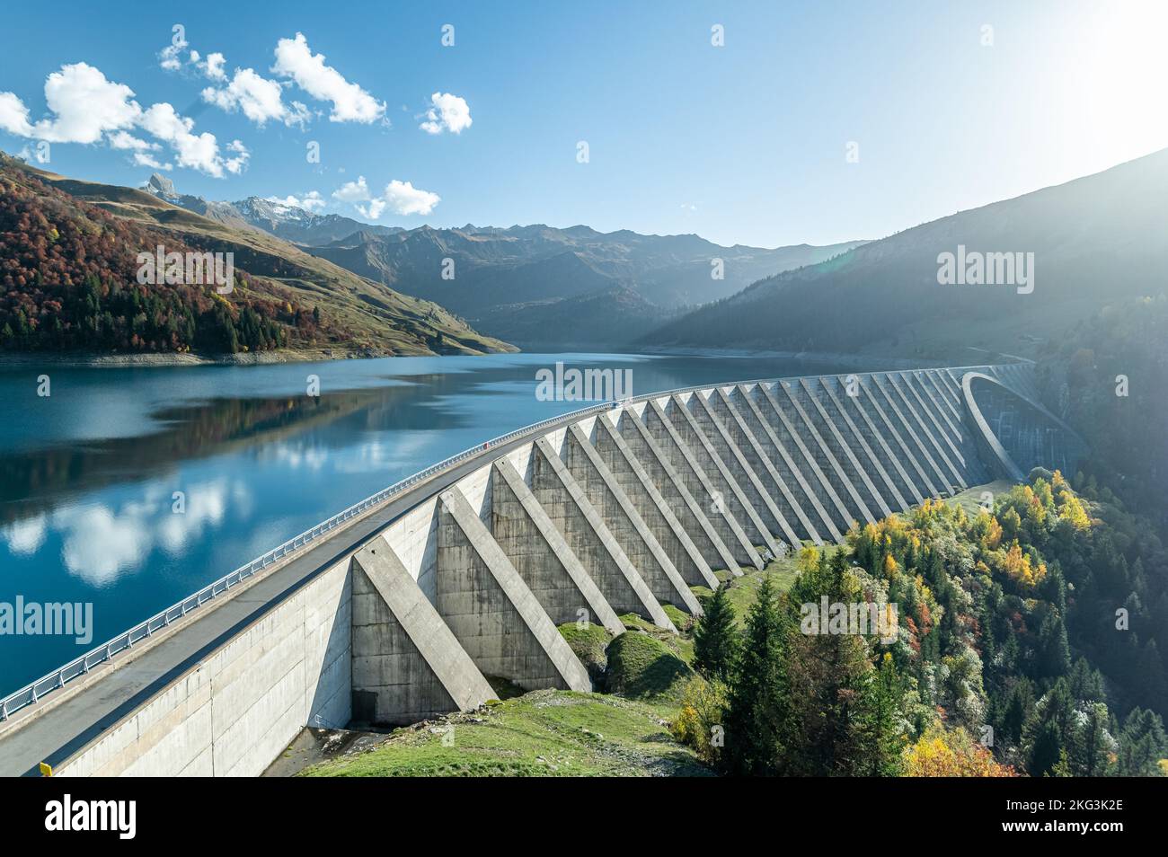 Prospettiva aerea della centrale idroelettrica sul lago Roselend, caratterizzata da una stretta strada su una diga in cemento armato che ospita un serbatoio d'acqua nelle Alpi francesi Foto Stock