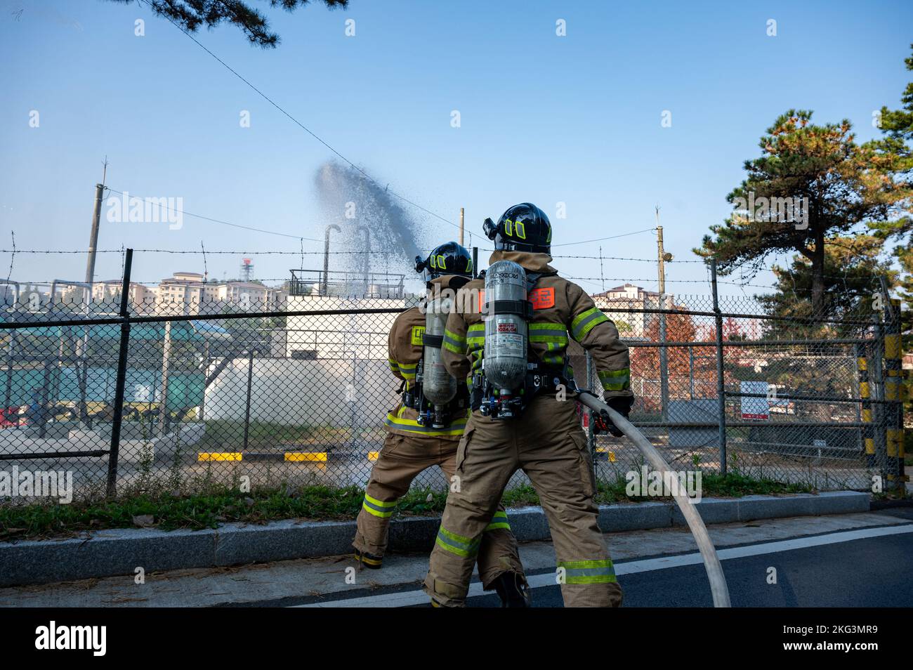 I vigili del fuoco dell'aeronautica della Repubblica di Corea spruzzano acqua su un incendio simulato durante un esercizio di addestramento congiunto con l'ingegnere civile 51st Squadron Fire Department presso la base aerea di Osan, ROK, 27 ottobre 2022. I servizi antincendio proteggono la vita e la proprietà all'interno di Osan AB e della comunità circostante. Foto Stock