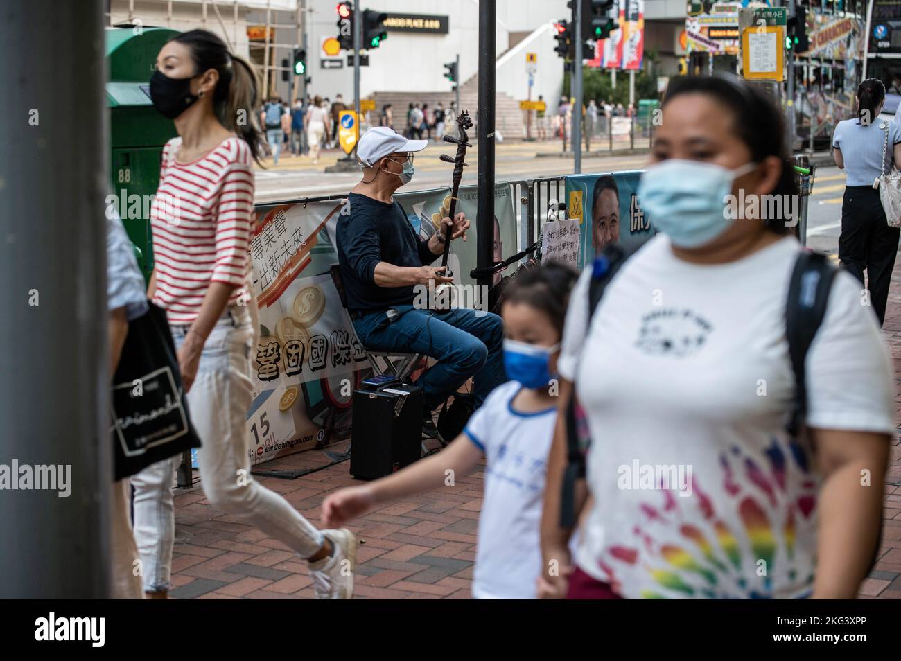 La gente cammina accanto a un musicista che suona "Glory to Hong Kong" e "Do you here the People Sing?" Su un erhu di fronte alla Stazione di Quarry Bay a Hong Kong. "Glory to Hong Kong”, considerato un inno non ufficiale delle proteste a favore della democrazia del 2019, ha fatto notizia ultimamente perché è stato scambiato per l'inno nazionale cinese in occasione di numerosi eventi internazionali di rugby. A Hong Kong, permangono dubbi circa la legalità di suonare o di eseguire questa canzone in pubblico ai sensi della legge sulla sicurezza nazionale. (Foto di ben Marans/SOPA Images/Sipa USA) Foto Stock