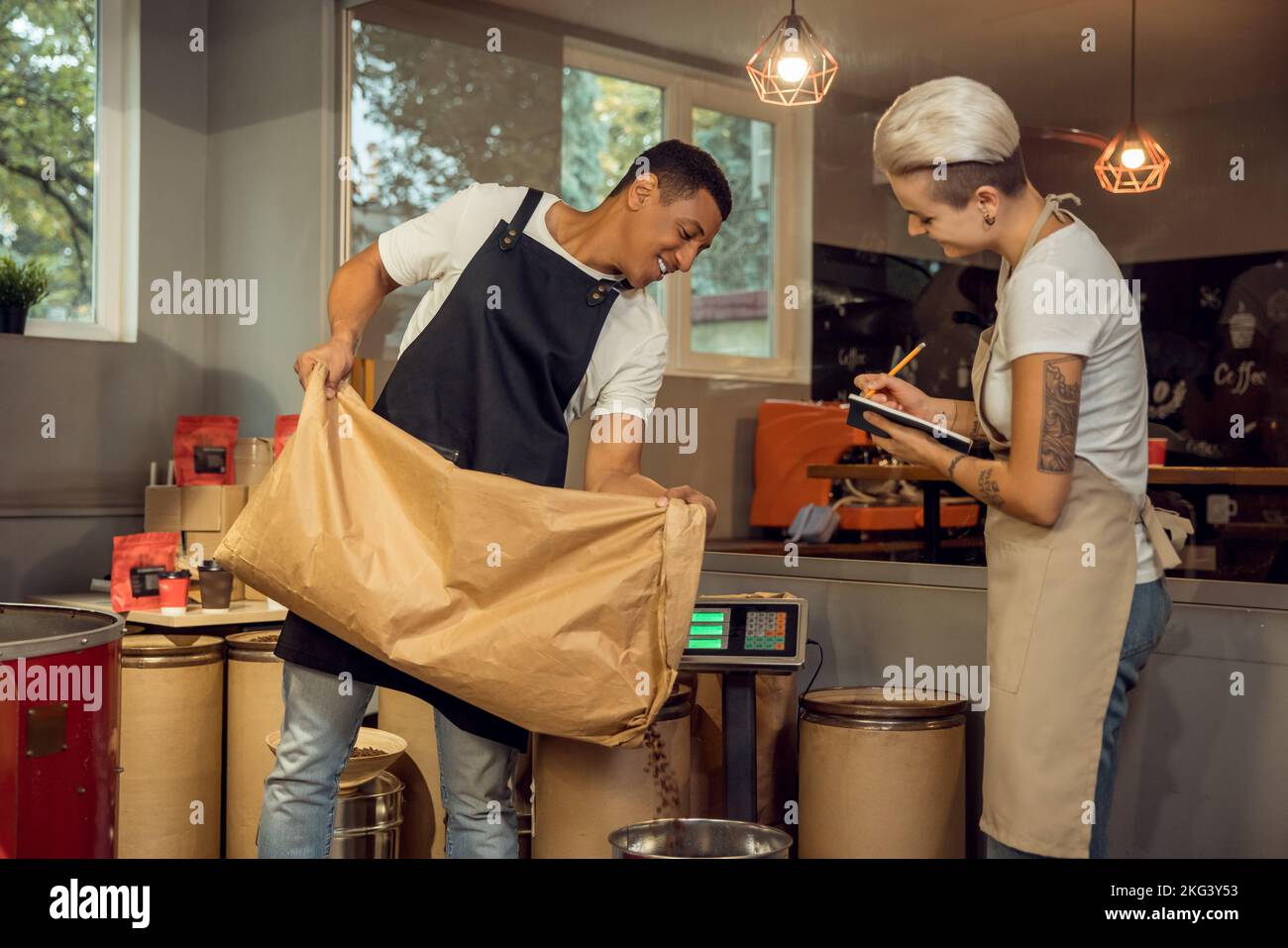 Personale che misura il peso di un prodotto sulla bilancia Foto Stock