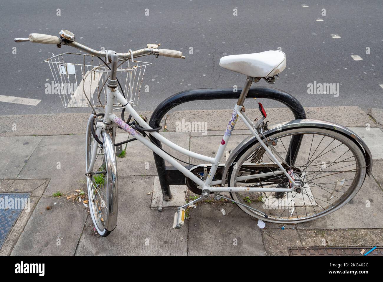 Vecchia bici bianca parcheggiata nelle strade di Kilburn Foto Stock