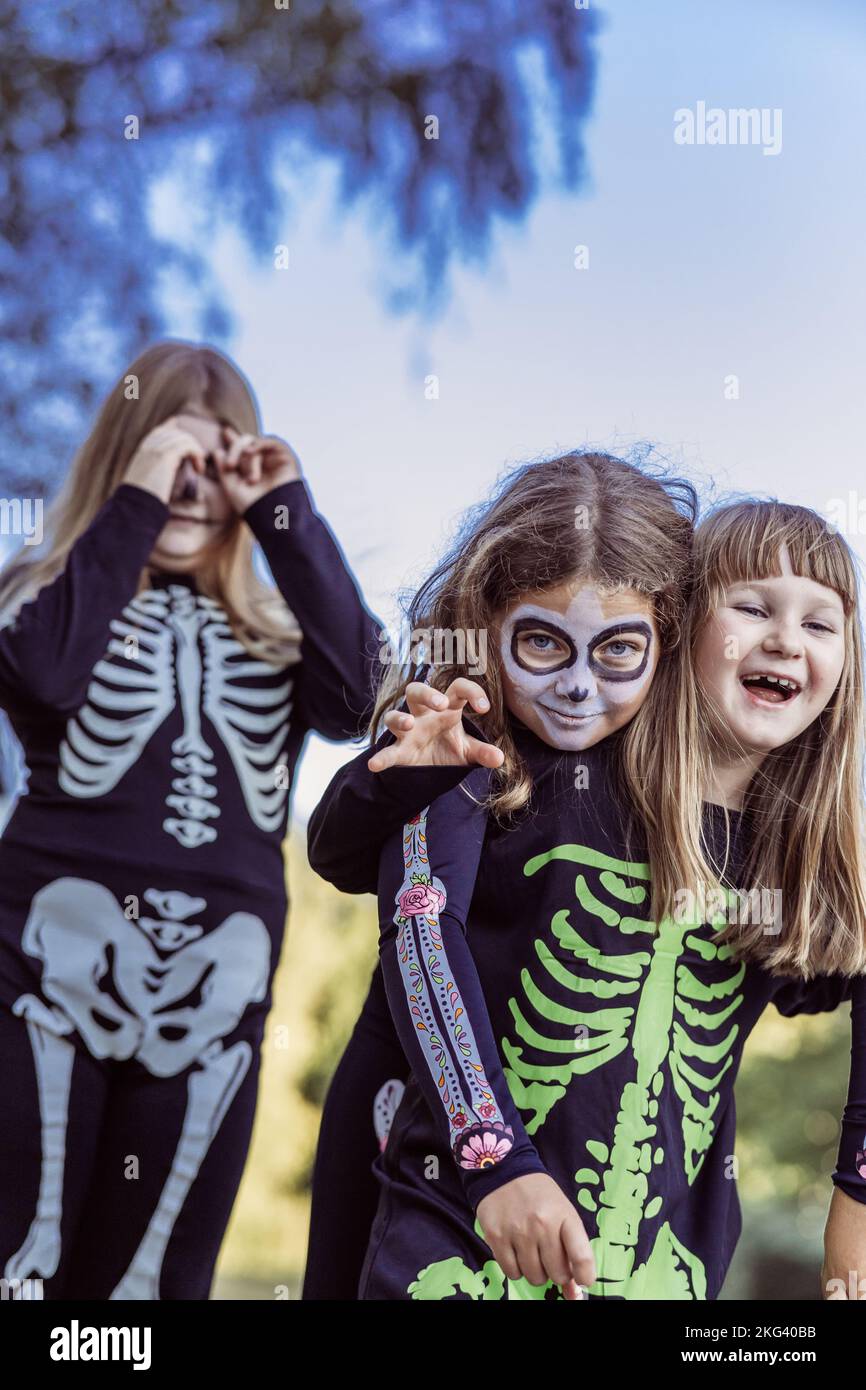 I bambini festeggiano una festa in costume di Halloween nel giardino sul retro Foto Stock