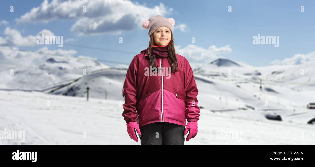 Ragazza che indossa abiti invernali impermeabili in una località sciistica innevata Foto Stock