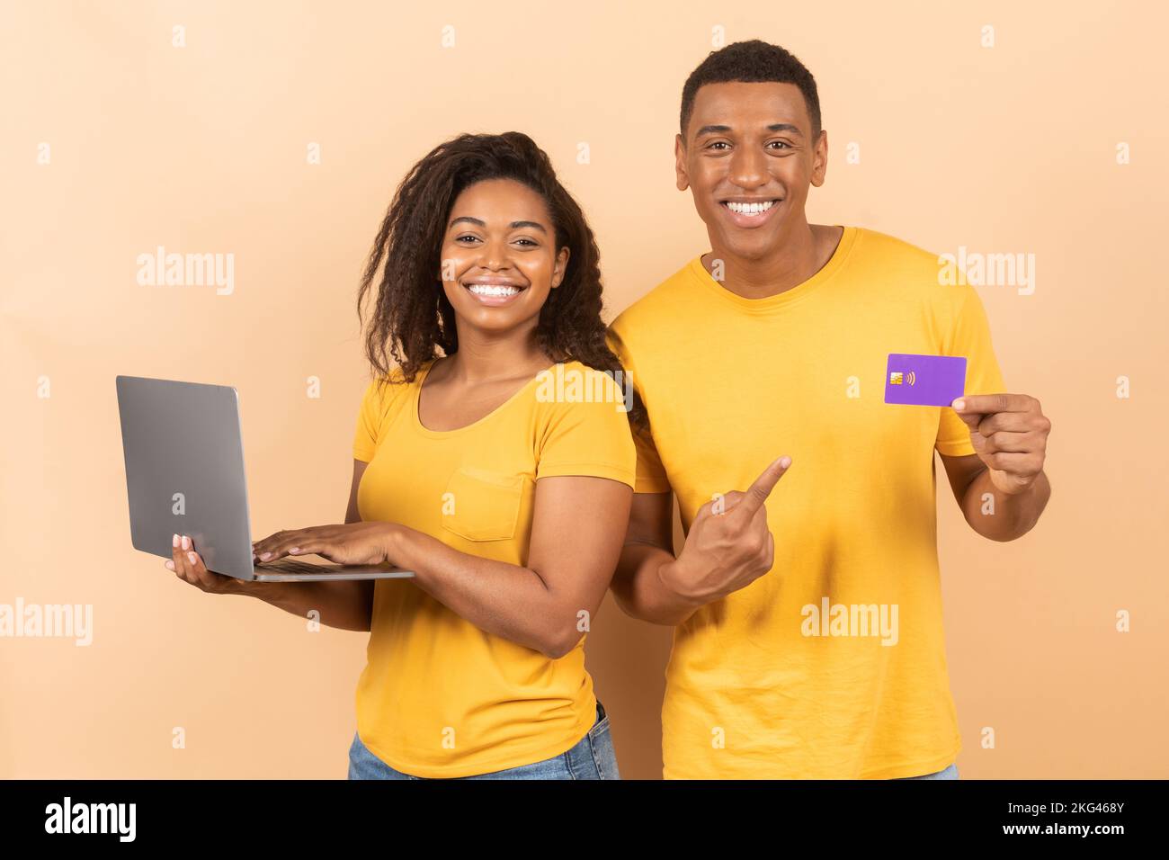 Shopping online, Black friday e pagamento con denaro. Donna nera felice che tiene il laptop, ragazzo che mostra la carta di credito Foto Stock