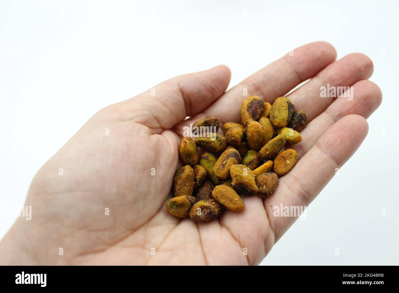 Pistacchio senza conchiglie. Pistacchio nelle mani di una donna. Le noci di pistacchio sono una proteina vegetariana sana e un alimento nutriente. Noci condimento chili. Foto Stock