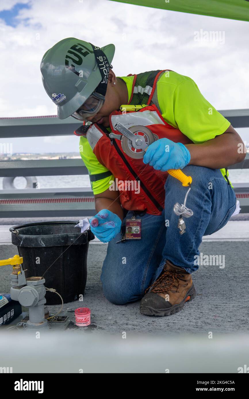 Matthew Bacnis, un Naval Supply Systems Command (NAVSUP) Fleet Logistics Center (FLC) Pearl Harbor Fuel Distribution System Specialist, misura il livello di carburante di un serbatoio a bordo della U.S. Navy Fuel Oil Barge (YON 328), durante un'operazione di disimballaggio presso la Joint base Pearl Harbor-Hickam (JBPHH), Hawaii, 28 ottobre 2022. L'operazione di disimballaggio rimuoverà circa un milione di galloni di carburante dalle tre tubazioni del carburante principali che collegano l'impianto di stoccaggio del carburante alla rinfusa (RHBFSF) di Red Hill ai punti del carburante sul JBPHH. JTF-RH è stato istituito dal Dipartimento della Difesa per garantire la dealimentazione sicura e rapida Foto Stock