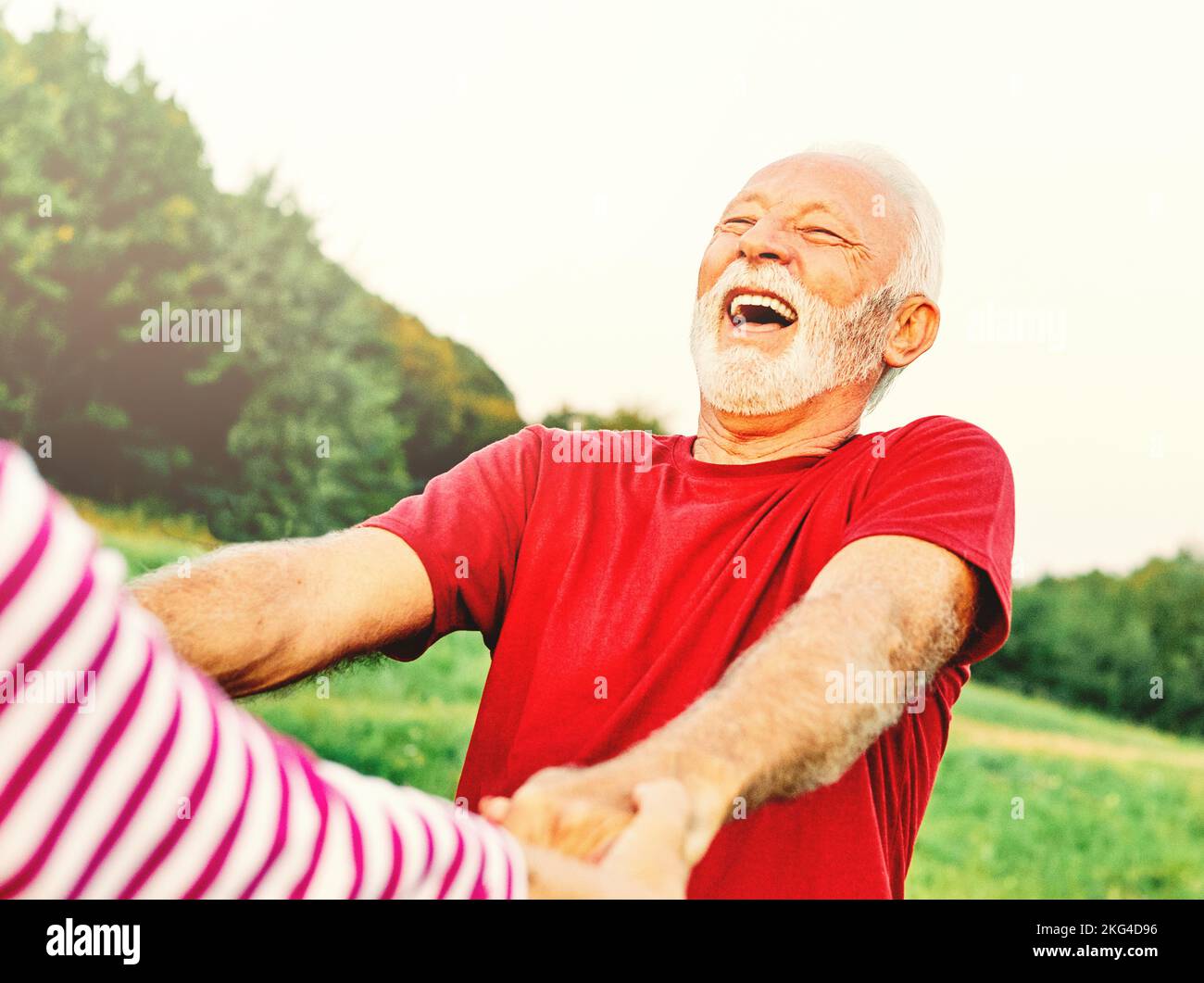 donna uomo outdoor coppia anziano felice lifestyle pensione insieme sorridente amore danza divertimento gioco attivo vitalità natura matura Foto Stock