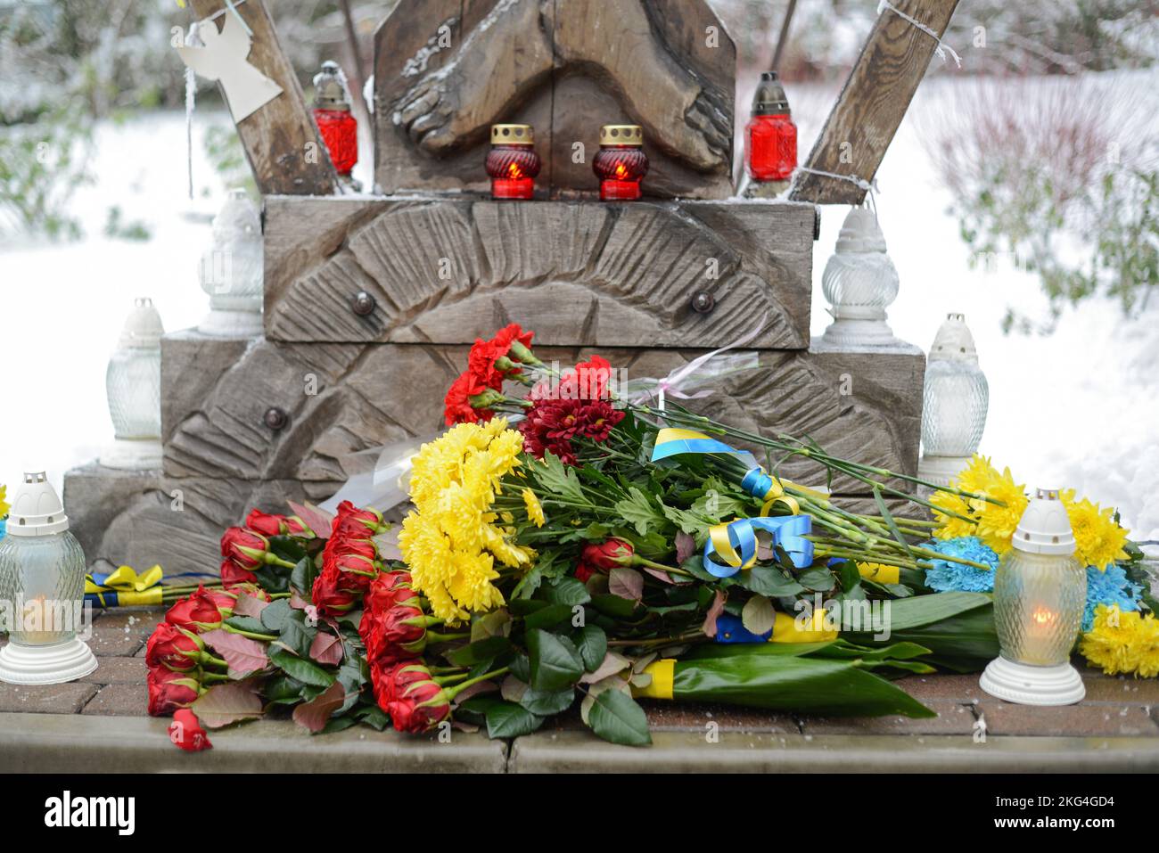KIEV, UCRAINA - 21 NOVEMBRE 2022 - i fiori e le lanterne di veglia sono raffigurati al monumento della Crocifissione di Cristo durante l'evento commemorativo per il Foto Stock
