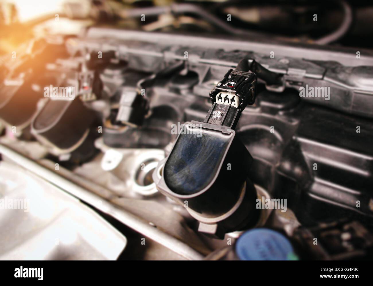 La spina del connettore elettronico della bobina di accensione del veicolo nel vano motore è stata rimossa, concetto di riparazione del veicolo Foto Stock