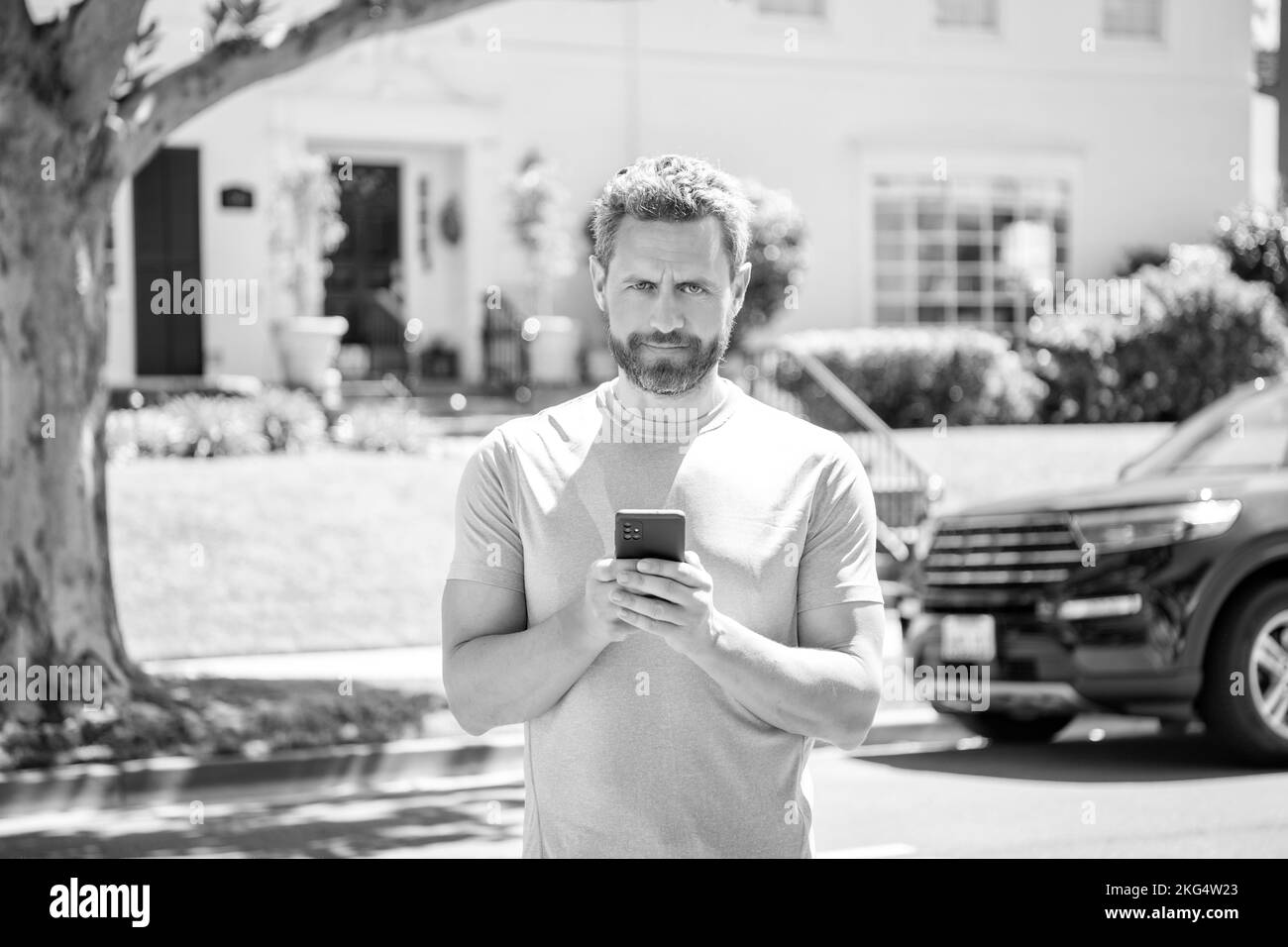 uomo maturo sorridente concessionario chattare online noleggio auto, concessionaria Foto Stock