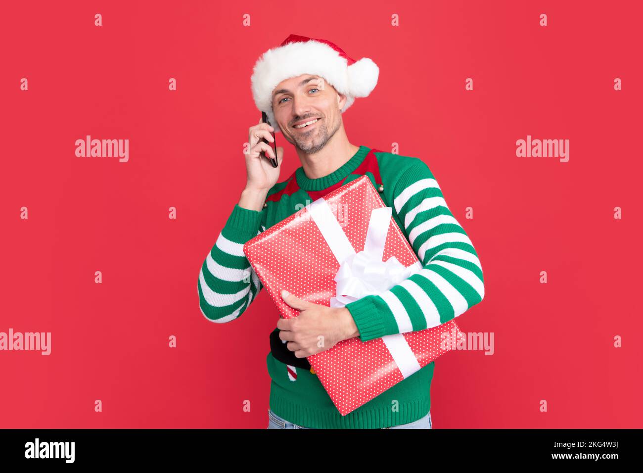 elfo allegro parlare al telefono. uomo in babbo natale cappello saluto on-line al telefono Foto Stock