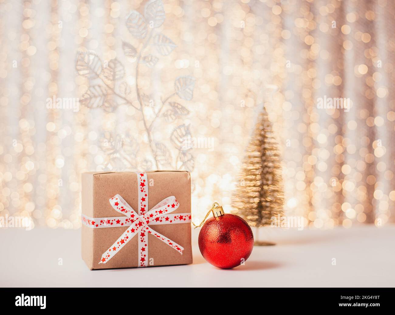 Scatola regalo di Natale su sfondo bokeh oro. Foto Stock
