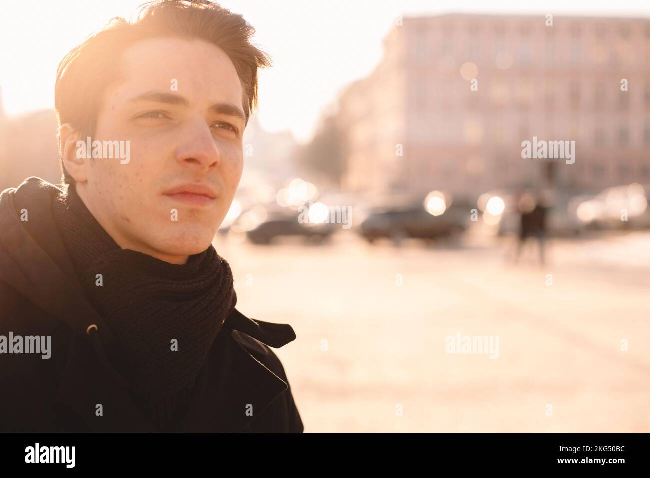 Ritratto di un ragazzino triste e premuroso in piedi in città durante l'inverno Foto Stock