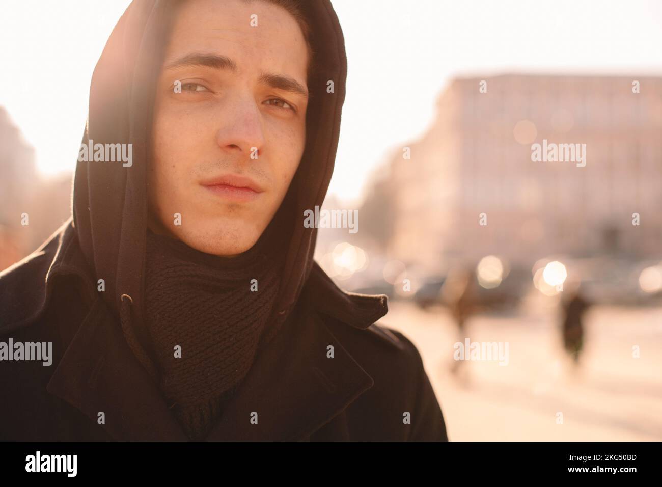 Triste ragazzo adolescente che indossa il cappuccio in piedi in città in inverno Foto Stock
