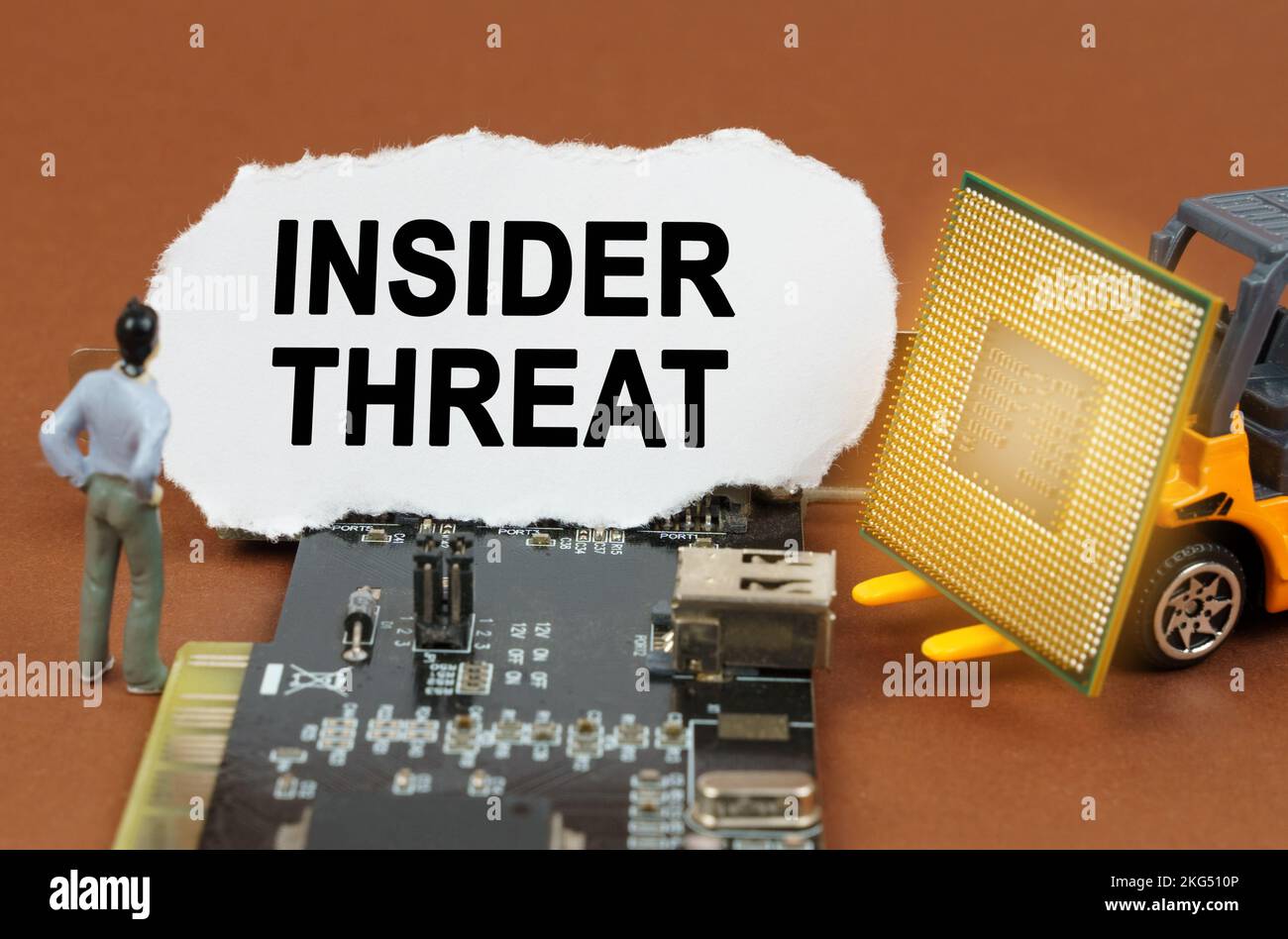 Concetto di computer. Sulla scheda con microcircuiti si trova una lastra di carta con l'iscrizione - Insider Threat. Nelle vicinanze si trova un caricatore di giocattoli con un processore An Foto Stock