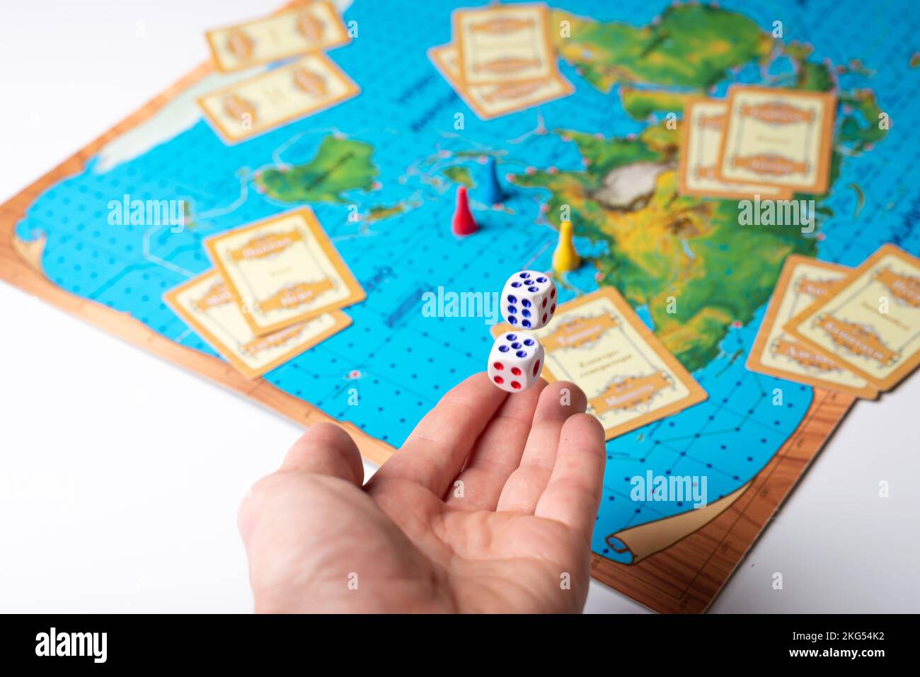 La mano lancia dadi con numeri sul gioco da tavolo Foto Stock