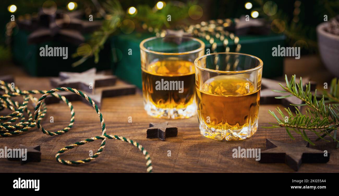 Due bicchieri di whiskey o bourbon con decorazioni natalizie Foto Stock