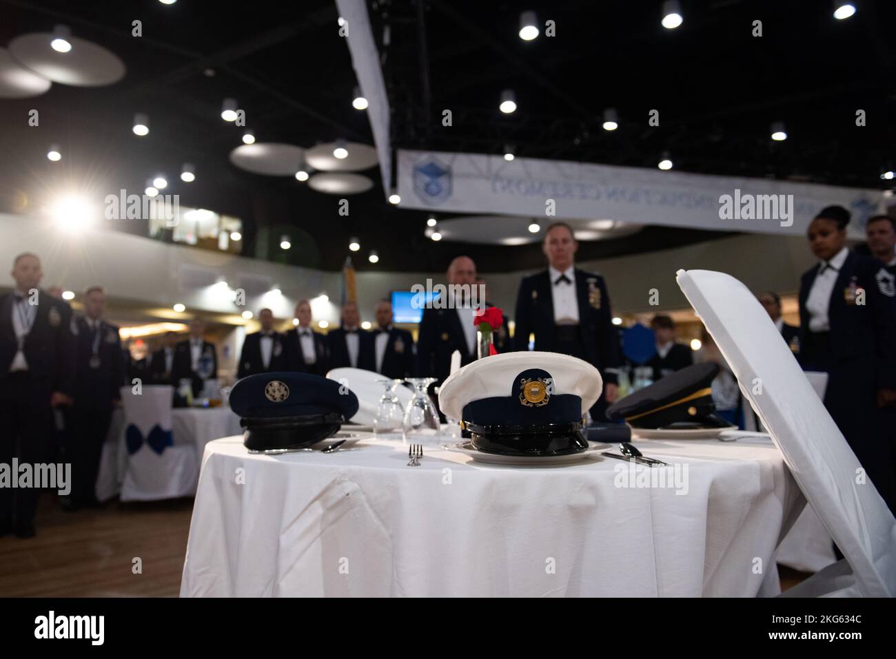 I partecipanti si fermaneranno per un momento di silenzio in ricordo di coloro che sono scomparsi in azione e prigionieri di guerra durante una cerimonia di investitura di un dirigente non commissionato presso la base aerea di Osan, Repubblica di Corea, 6 ottobre 2022. La tavola POW/mia è impostata con una fetta di limone per indicare il destino amaro, sale per le lacrime delle famiglie colpite e bicchieri rovesciati per l’incapacità di coloro che hanno perso di condividere il toast della giornata. Foto Stock
