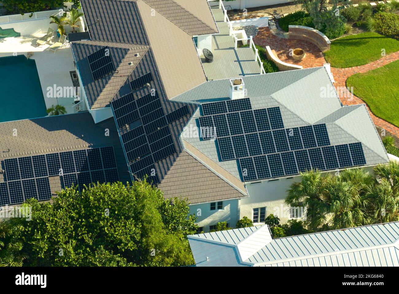 Vista aerea di un nuovo e costoso tetto americano con file di pannelli solari fotovoltaici blu per la produzione di energia elettrica ecologica pulita Foto Stock