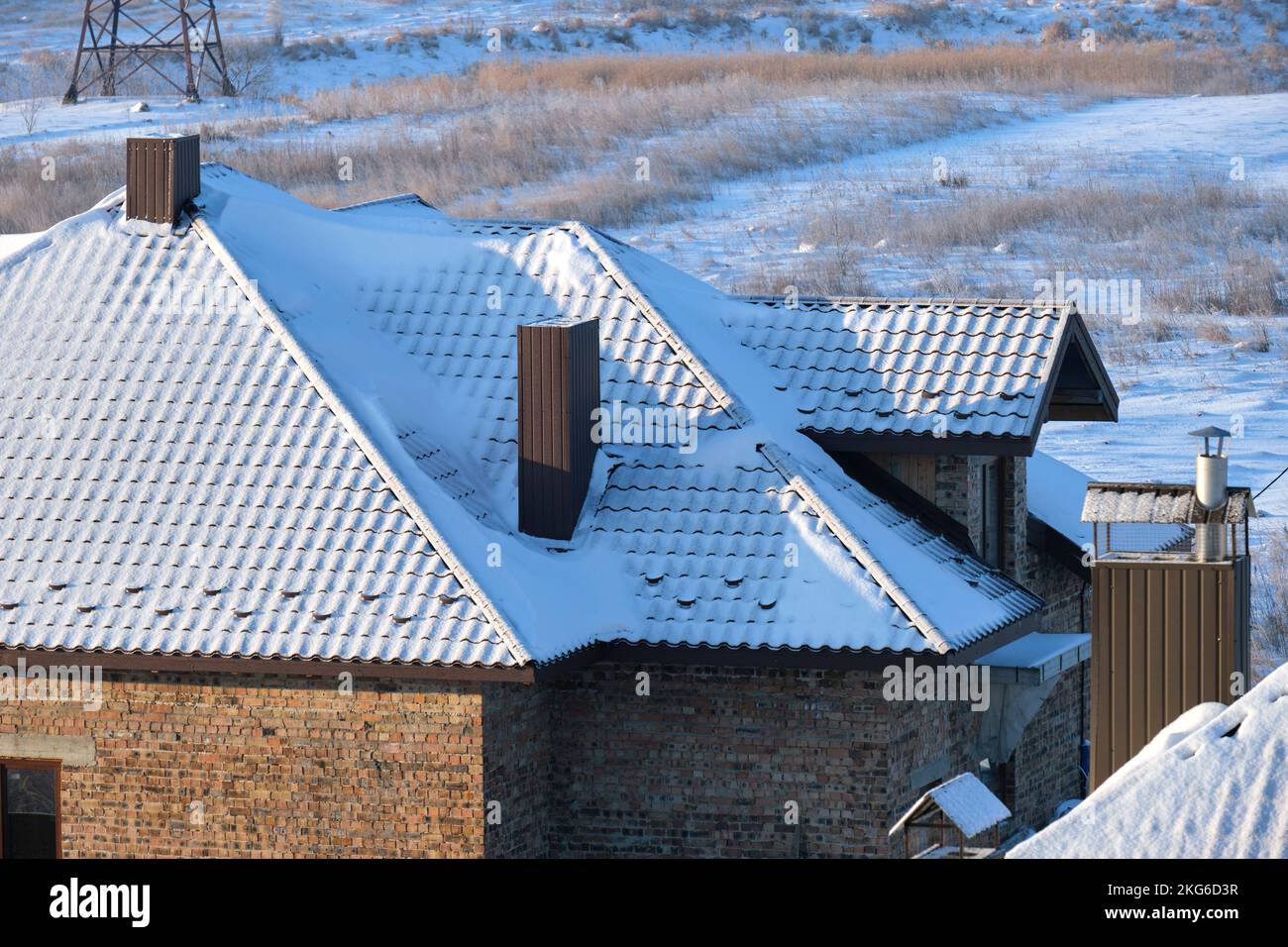 Protezione da neve per la sicurezza in inverno sul tetto della casa coperto con scandole in ceramica. Rivestimento piastrellato dell'edificio Foto Stock