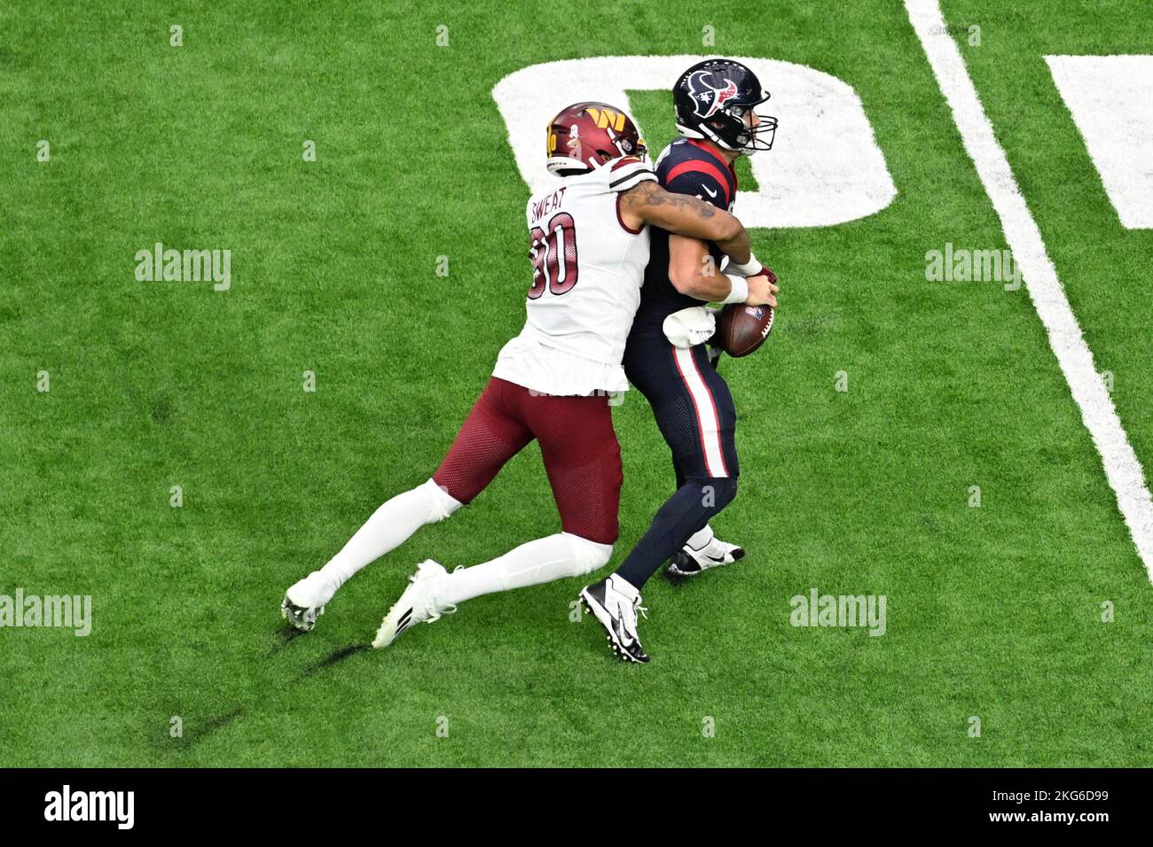 Washington Comanders Defensive End Montez Sweat (90) sacks Houston Texans quarterback Davis Mills (10) durante la NFL Football Game tra i Washi Foto Stock