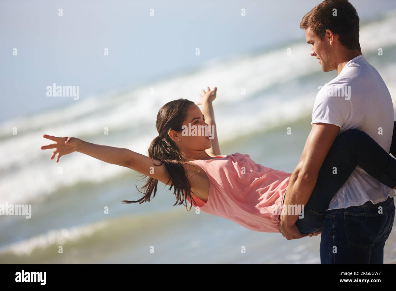 Guarda, senza mani. una giovane coppia è giocosa sulla spiaggia. Foto Stock