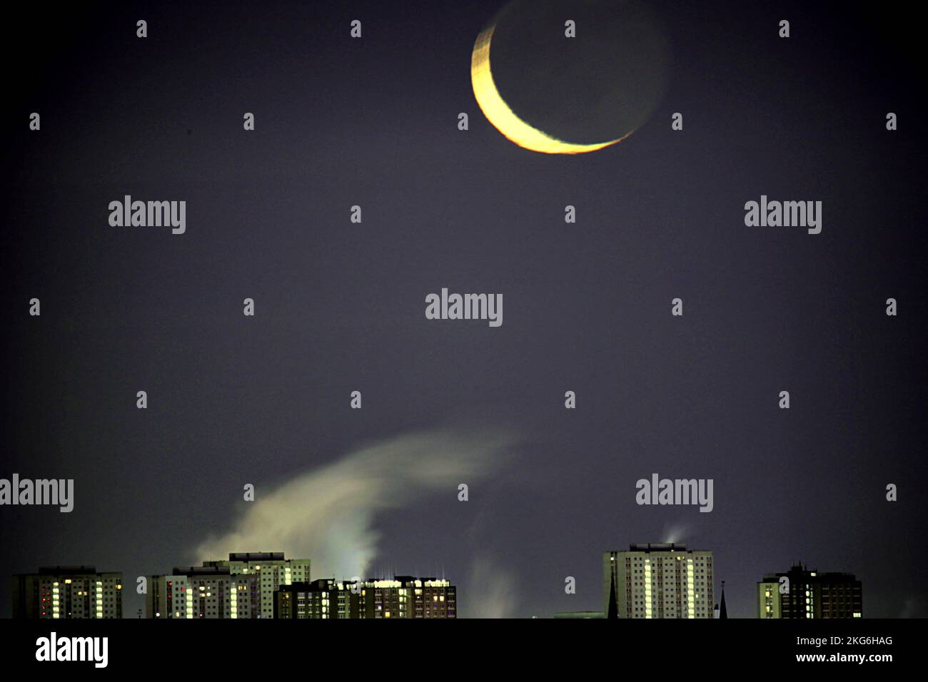 Glasgow, Scozia, Regno Unito 22nd novembre 2022. UK Weather: Gancio della luna crescente sbirciò attraverso la copertura della nuvola mentre l'intera luna della mezzaluna seguì più tardi sopra i grattacieli del centro ciottoso. Credit Gerard Ferry/Alamy Live News Foto Stock