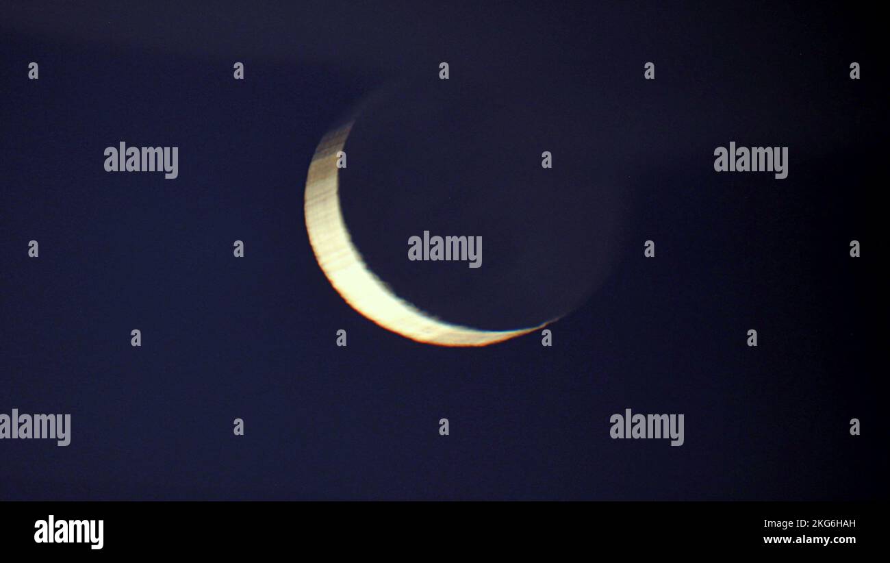 Glasgow, Scozia, Regno Unito 22nd novembre 2022. UK Weather: Gancio della luna crescente sbirciò attraverso la copertura della nuvola mentre l'intera luna della mezzaluna seguì più tardi sopra i grattacieli del centro ciottoso. Credit Gerard Ferry/Alamy Live News Foto Stock