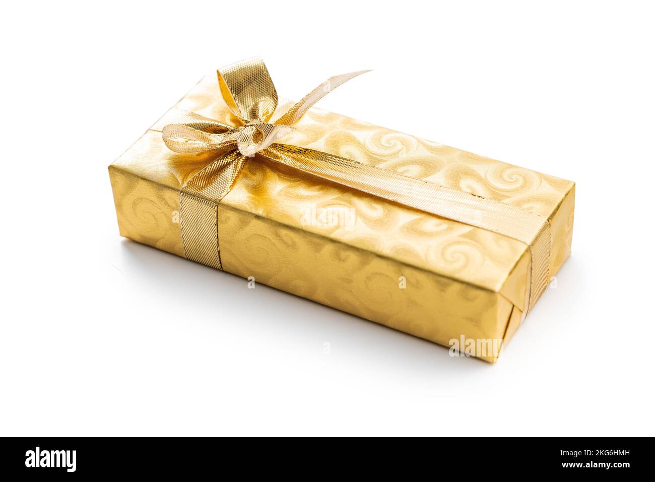 Regalo avvolto in foglio d'oro. Regalo di Natale con nastro d'oro isolato su sfondo bianco. Foto Stock