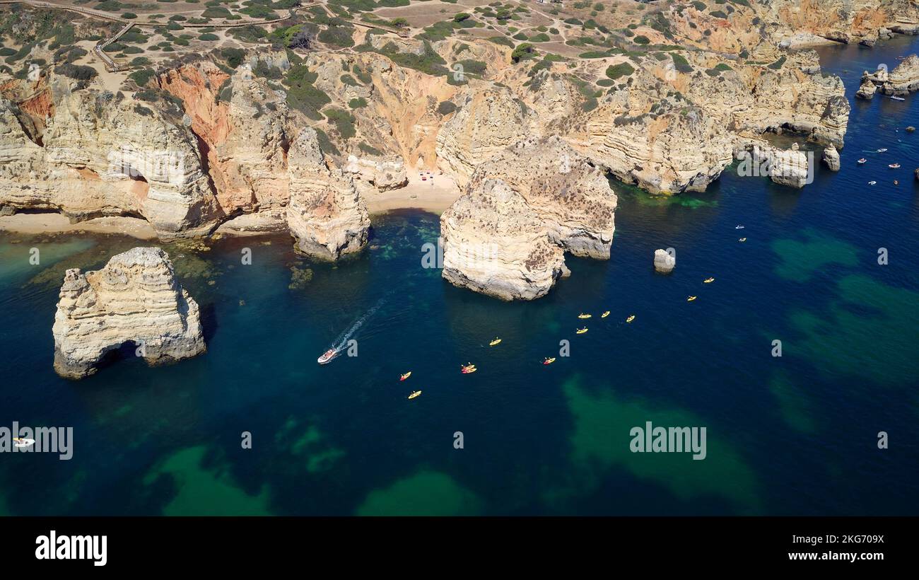 Vista aerea dei droni di barche e kayak nell'Oceano Atlantico, Lagos, Algarve, Portogallo. Esplorazione di grotte e tunnel. Viaggi e avventura. Vacanze. Foto Stock