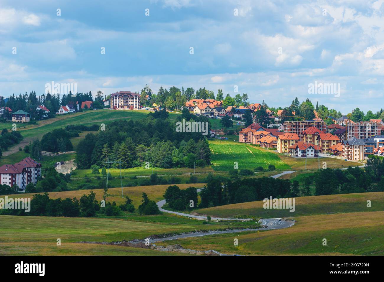 Bellissimo paesaggio pittoresco della regione di Zlatibor con case in stile architettonico distintivo sparse sulle verdi colline nelle soleggiate giornate estive Foto Stock