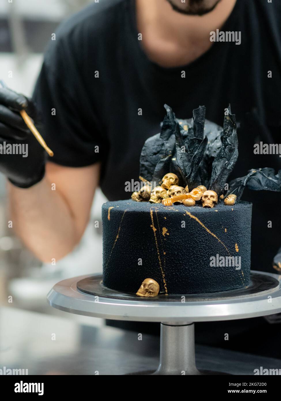 pasticciere finendo horror nero torta di compleanno muertos decorazione con  teschi commestibili dorati e vele di carta di riso nero Foto stock - Alamy