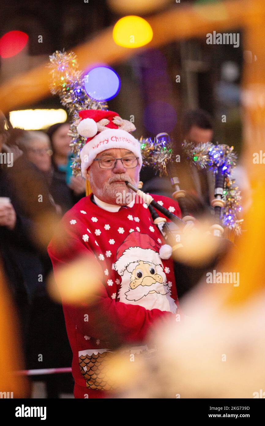 Interruttore luce di Natale su Lockerbie, Scozia, Lockerbie Pipe Band vestito con abito fantasia di Natale Foto Stock