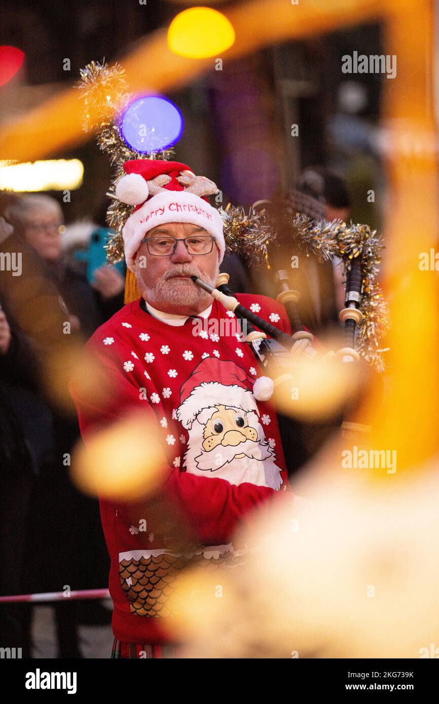 Interruttore luce di Natale su Lockerbie, Scozia, Lockerbie Pipe Band vestito con abito fantasia di Natale Foto Stock