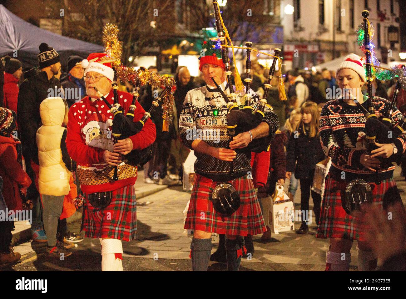 Interruttore luce di Natale su Lockerbie, Scozia, Lockerbie Pipe Band vestito con abito fantasia di Natale Foto Stock