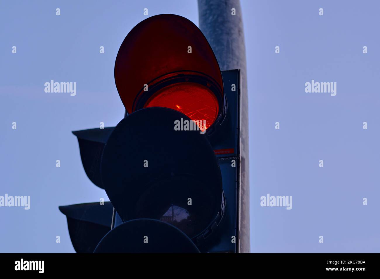Primo piano di un semaforo rosso contro un cielo limpido, segnalando ai veicoli di fermarsi e garantendo la sicurezza stradale. Luce rossa, ferma. Foto Stock