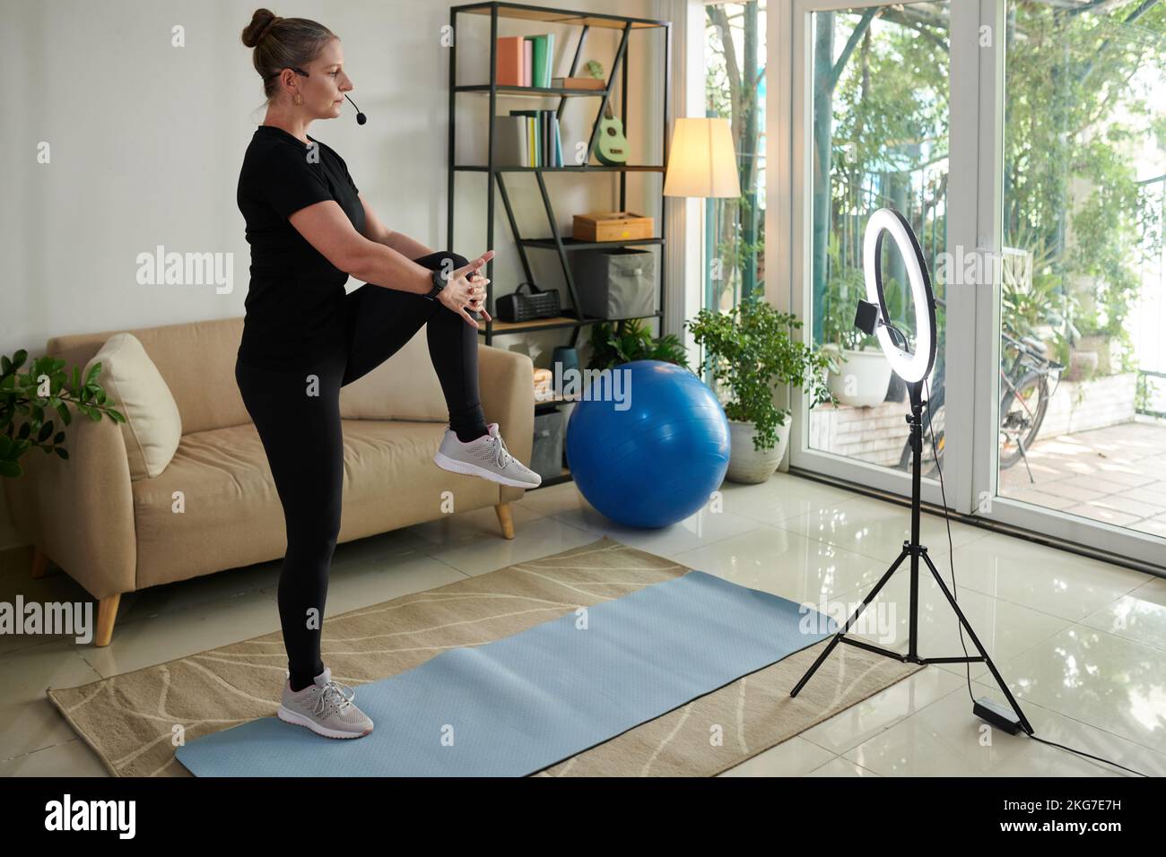 Fitness blogger filmare se stessa riscaldamento a casa Foto stock - Alamy