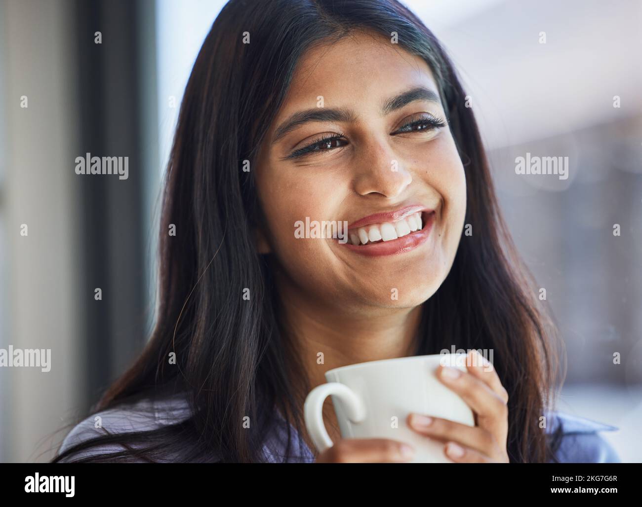 Donna, sorriso e tazza di caffè a casa per pensare, rilassarsi o la visione in salotto, finestra o stanza. Ragazza, felice e bere tazza per bevande, tè o. Foto Stock