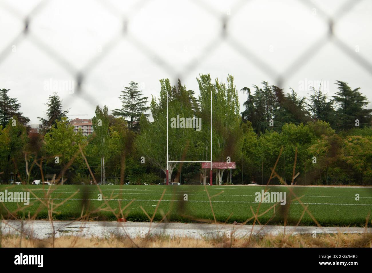 campo di rugby con la porta sullo sfondo e l'immagine scattata da dietro una recinzione Foto Stock