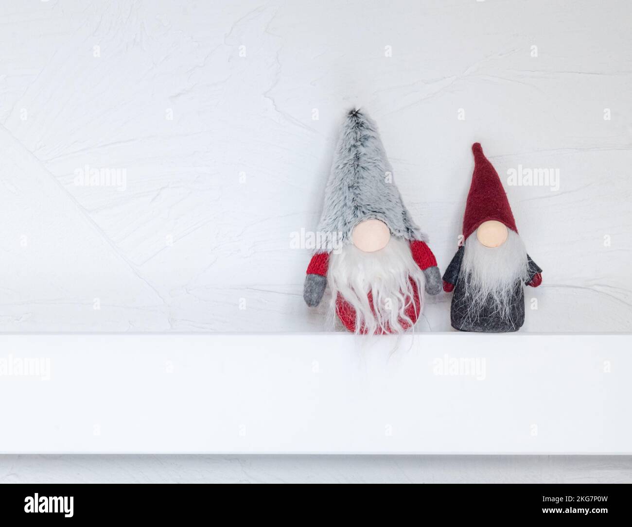 Elfi, decorazioni natalizie. I Gonks di Natale siedono su una mensola di legno bianca contro il muro. Concetto di Natale e Capodanno, biglietto d'auguri, spazio copia Foto Stock