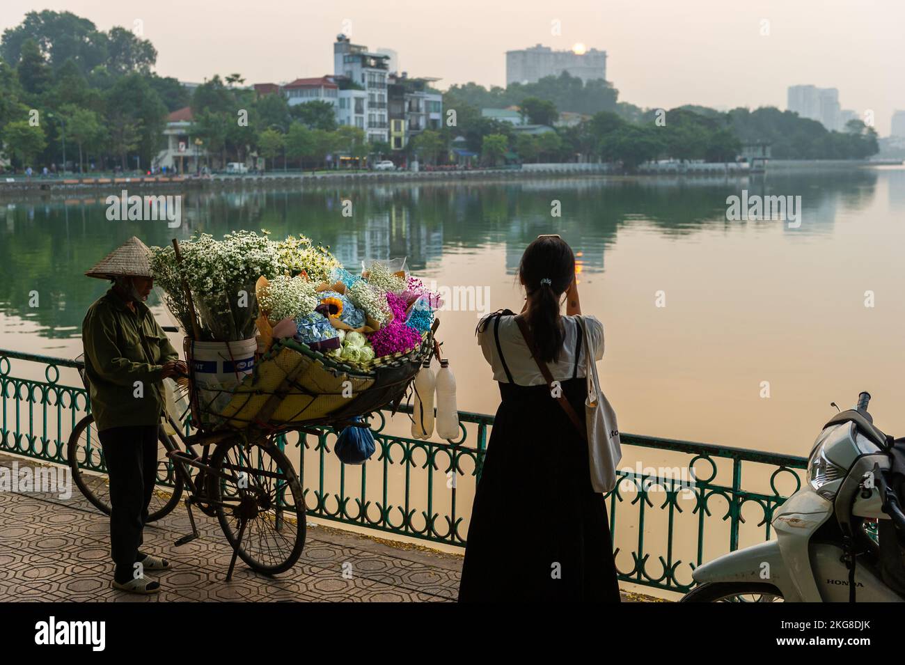 Vendere fiori e scattare foto al tramonto sul lago Hồ Tây, Hanoi Vietnam Foto Stock