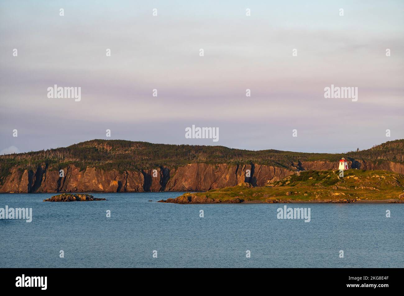 Canada, Labrador, Terranova, Trinity, costa marina con il lontano faro di Fort Point al tramonto Foto Stock