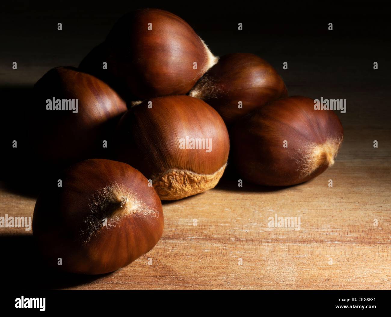 Castagne pronte per arrostire per la festa su blocco macellaio Foto Stock