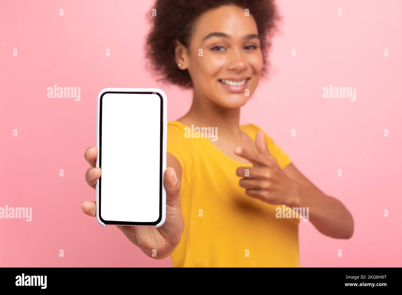 Sorridente donna afroamericana centenaria punta il dito sul telefono con schermo vuoto Foto Stock