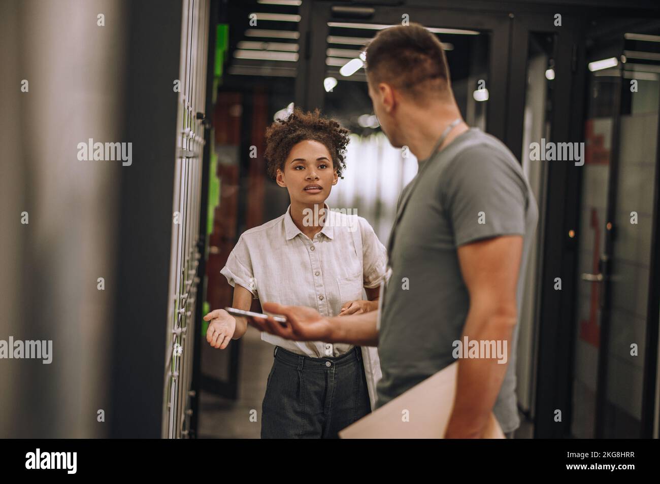 Una dipendente femminile che ha una conversazione con la sua collega Foto Stock