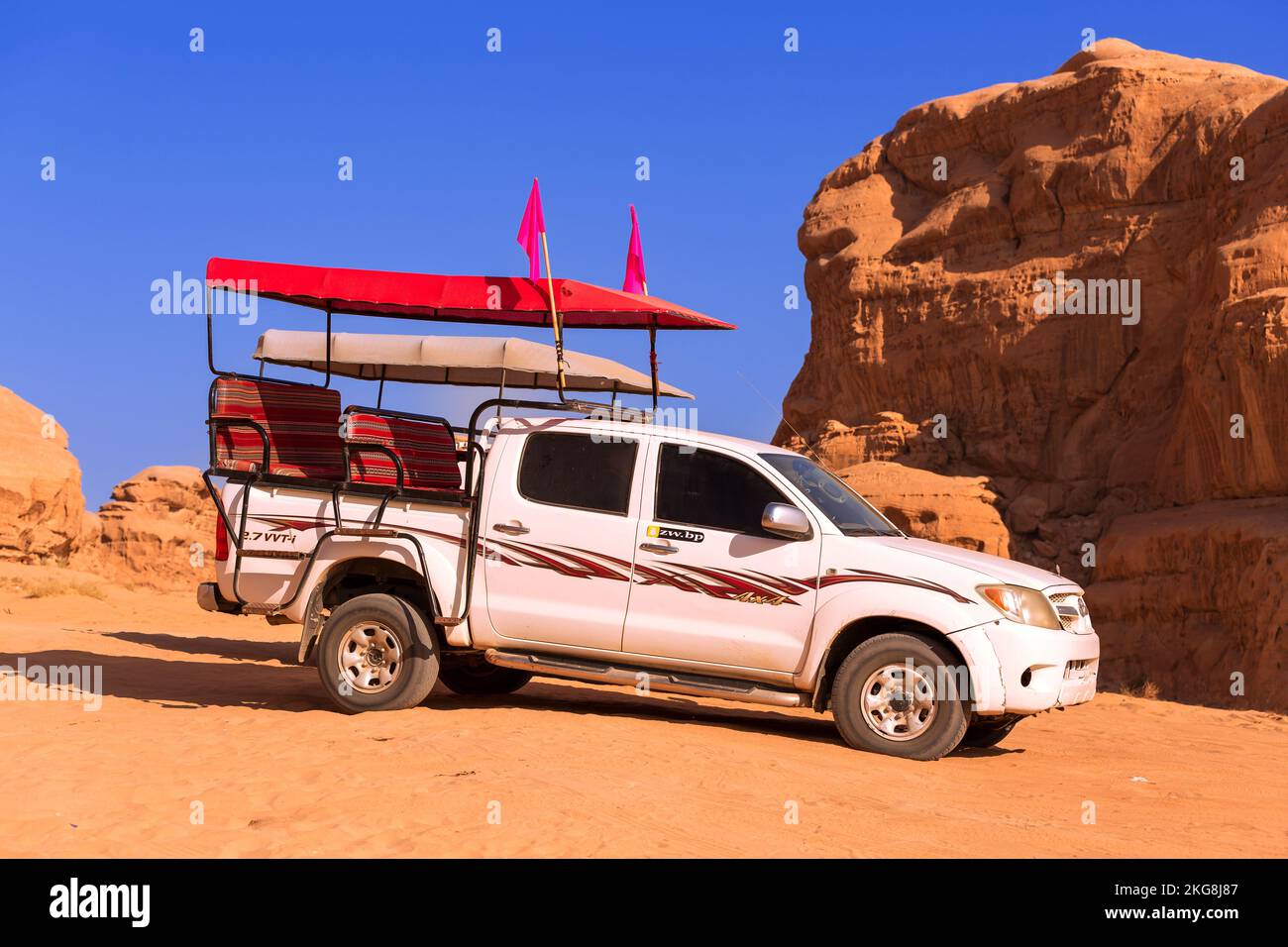 Giordania, Wadi Rum - 2 novembre 2022: Jeep beduina tour auto nel deserto con scogliera montagna rocciosa sullo sfondo Foto Stock