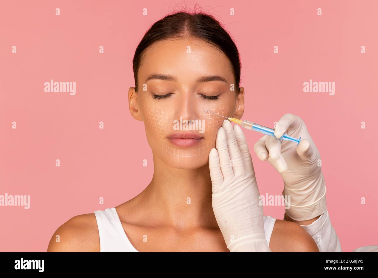 Dottore estetista fare l'iniezione alla donna bella con maglia disegnata sul viso Foto Stock