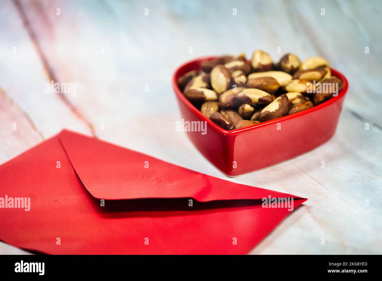 Dadi del Brasile in piatto a forma di cuore con carta busta. Regalo di San Valentino per qualcuno. Foto Stock